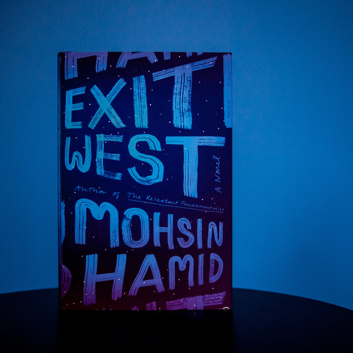 Exit West by Mohsin Hamid, a purple and blue book against a blue background